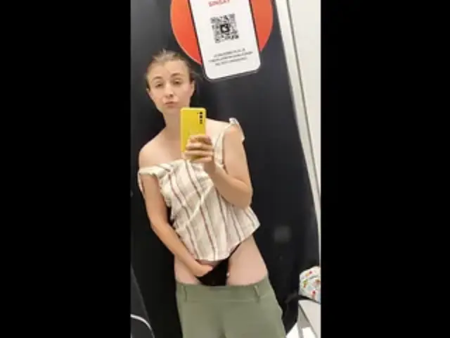 In the fitting room, a sexy girl fingers herself and tastes her own juice